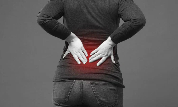 A woman suffering from sciatica pain holds her lower back