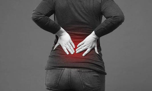 A woman suffering from sciatica pain holds her lower back